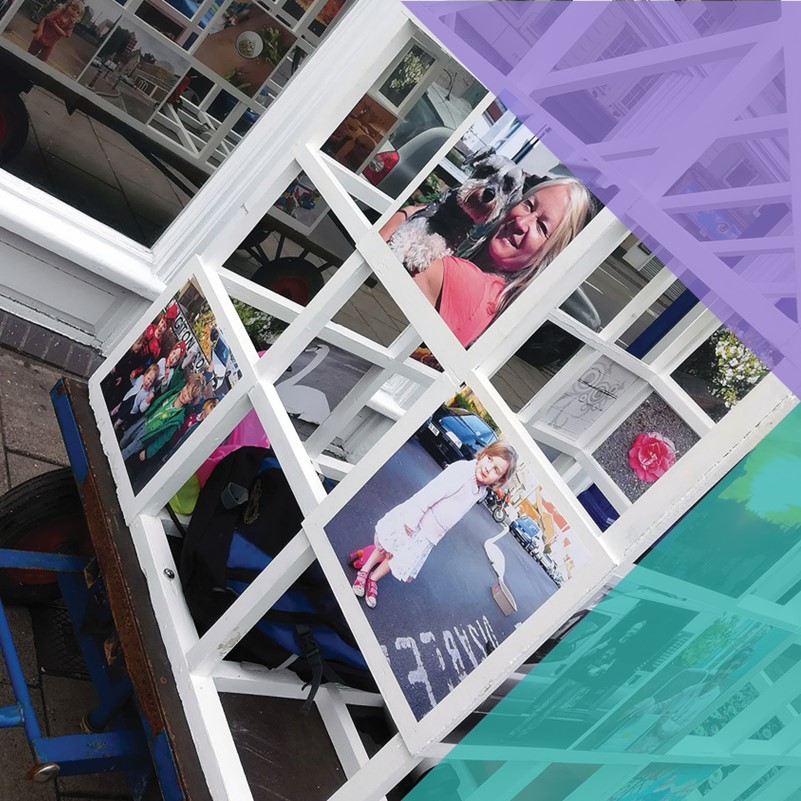 A photograph of a 'MobileHome Gallery' with photos of the community exhibited on a moving frame house